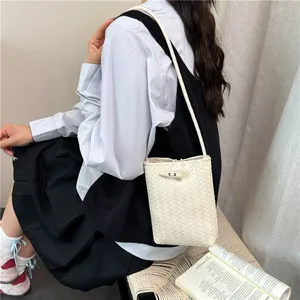Vue détaillée du mini sac bandoulière tressé, cuir souple et fermeture à bascule élégante.