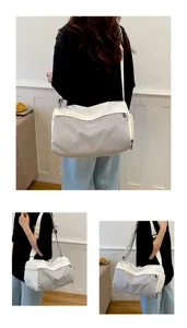Vista detallada del gran bolso de viaje tipo bandolera para mujer en estilo bloque de gris.