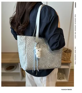 Vue détaillée du sac cabas imprimé léopard gris avec bandoulière et joli pendentif.