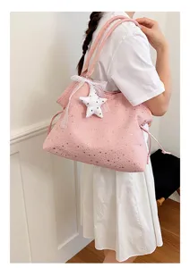 Detailansicht der rosa Tote-Bag mit Sternen-Print, Spitze und Plüschstern-Anhänger.