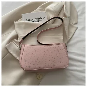 Détail de sac à épaule rose, motif d'étoiles argentées, style baguette élégant et chic.