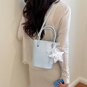 Chic light blue bucket bag with lace star pendant, stylish shoulder and crossbody handbag.