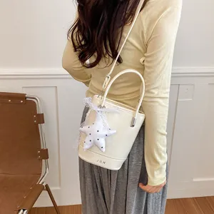 Korean style minimalist bucket bag with star plush charm and lace ribbon, stylish shoulder handbag.