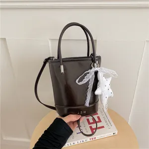 Dark brown bucket bag fine product detail, featuring cute white lace bow and star charm.