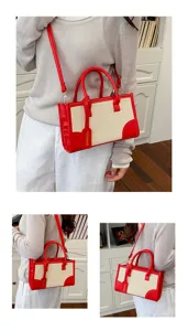 Vista detallada del bolso de lona rojo y beige para mujer con costuras, asas y correa ajustable.