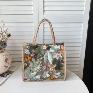 Nahaufnahme der Pailletten bestickten Jute-Tasche mit Blumendesign und stabilen Griffen.