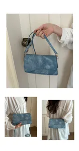 Gedetailleerd overzicht van de chique blauwe denim okseltas met kwaliteitsstof en elegante flap.