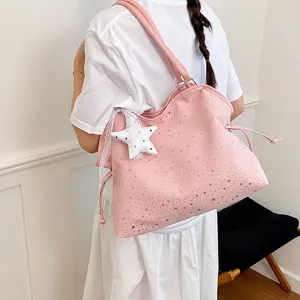 Rosa Schultertasche Detail mit silbernen Sternen, weichem Stoff und dekorativem Sternanhänger.