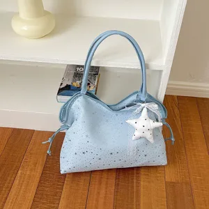 Detailansicht der hellblauen Tote-Bag mit silbernen Sternen und süßem Stern-Anhänger.