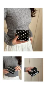 Detail view of the stylish black and white polka dot patent leather wallet, compact and chic.