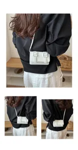 Nahaufnahme einer schicken weißen Mini-Umhängetasche mit doppelten Schnallenriemen am Model.