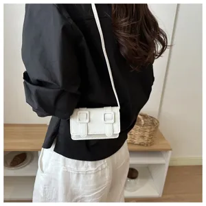 Detailansicht einer schicken weißen Umhängetasche im Miniformat zum lässigen Outfit.