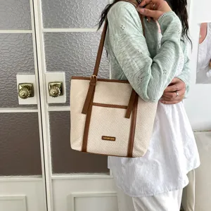 Detail view of stylish beige and brown tote shoulder bag, premium commuting handbag design.