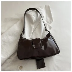 Donkerbruine lakleren oksel-schouder-tas met klinknagels in retro motorstijl detailweergave.