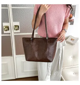 Dettaglio in primo piano della borsa tote a spalla in pelle marrone scuro, design.
