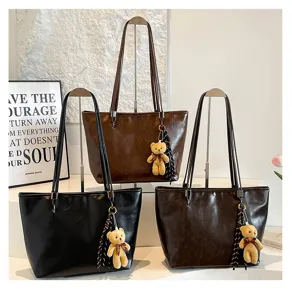 Detailansicht lässiger Pendler-Shopper Umhängetaschen mit süßem Bärenanhänger und Quasten.