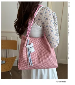 Pink woven tote bag detail showing stylish braided strap and cute plush rabbit charm accessory.