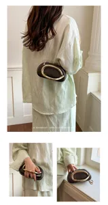 Minimalist retro women brown leather shoulder bag featuring a sculptural gold handle.