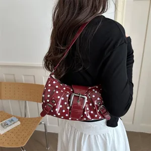 Retro lakleren schoudertas met polstippen, metalen gespen en stijlvol onderarm ontwerp.