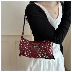 Rode laklederen schoudertas met witte stippen en stijlvolle gespdetails voor dames.