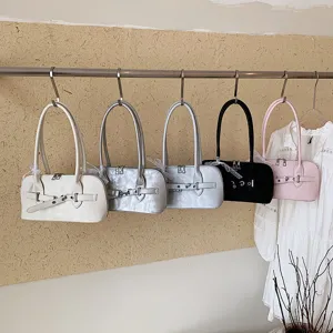 Detailopname van stijlvolle vintage schoudertassen aan een kledingrek met mooie gespen.