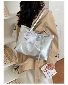 Vue détaillée d'un sac cabas d'épaule métallisé argenté élégant avec pendentif étoile.