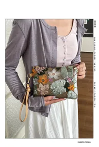 Vista dettagliata di una pochette ricamata con fiori di paillettes stile retro con polsino.