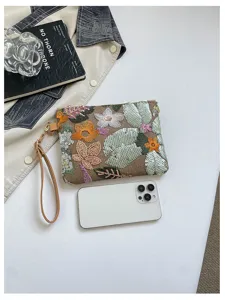 Vista dettagliata della pochette con ricamo floreale e paillettes, dotata di comodo laccetto.