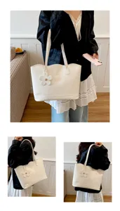 Grande borsa tote monocromatica semplice da donna con grazioso ciondolo floreale e capiente.