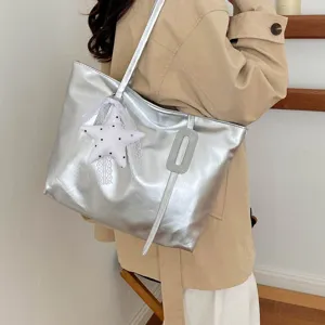Vue détaillée d'un sac cabas d'épaule métallisé argenté avec pendentif étoile blanche.