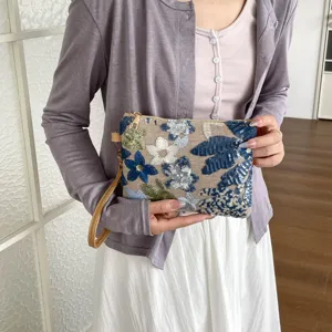 Vista dettagliata della pochette con ricamo di paillettes floreali e lavorazione fine.