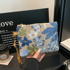 Vista dettagliata della pochette floreale ricamata di tendenza con paillettes, elegante borsa.