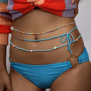 Primo piano della catena da vita in perline colorate tendenza gioiello da corpo estivo.