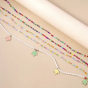 Catena da corpo multistrato con perline colorate e ciondoli a foglia d'acero eleganti.