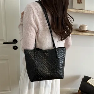 Detail view of black woven leather shoulder bag showcasing elegant design and large capacity.