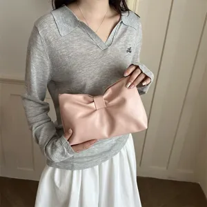 Close-up detail of the pink leather bow clutch bag, featuring elegant soft texture and chic style.