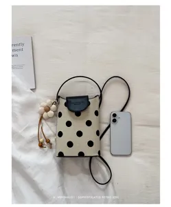 Retro Pünktchen Mini Umhängetasche für Handys mit süßem Blumenanhänger und schwarzer Klappe.