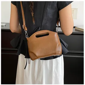 Vue de détail d'un sac à main marron en cuir PU pour femme avec poignée et bandoulière.