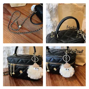 Sac matelassé noir avec bandoulière chaîne et pendentif poupée pour femmes.