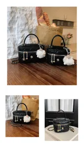 Sac à main matelassé noir avec bandoulière chaîne et charm poupée, chic et élégant.