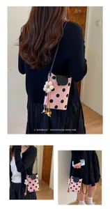 Rosa gepunktete kleine Handytasche Detailansicht mit Blumenanhänger und Lederklappe.