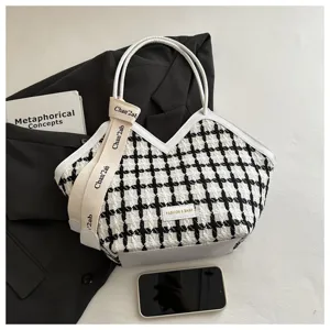 Zwart-witte houndstooth tweed tote tas met witte lederen handvatten en stijlvolle banden.