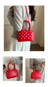 Red polka dot dome handbag detail showing stylish crossbody strap and cute design features.