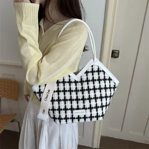 Zwart-witte houndstooth schoudertas detail, elegant ontwerp met witte lederen afwerking.