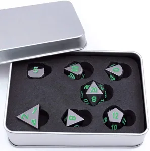 Détail d'un ensemble de dés polyédriques en métal noir et argent dans une boîte