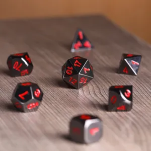 Gros plan d'un ensemble de dés polyédriques en métal noir et rouge pour jeux DND.