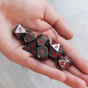 Gros plan détaillé d'un jeu de dés polyédriques en métal noir avec chiffres rouges