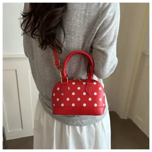 Detailed view of the red polka dot dome handbag showing stylish design and hardware.