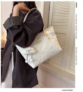 Detailed view of the stylish white tote bag with star patterns and a cute cloud plush pendant.