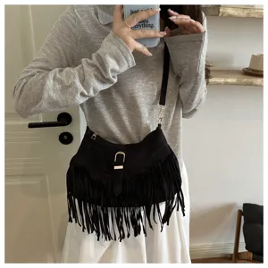 Black fringe shoulder bag detail view showcasing soft suede material and metal hardware.